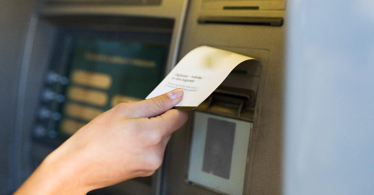 primer plano de la mano tomando el recibo del cajero automático